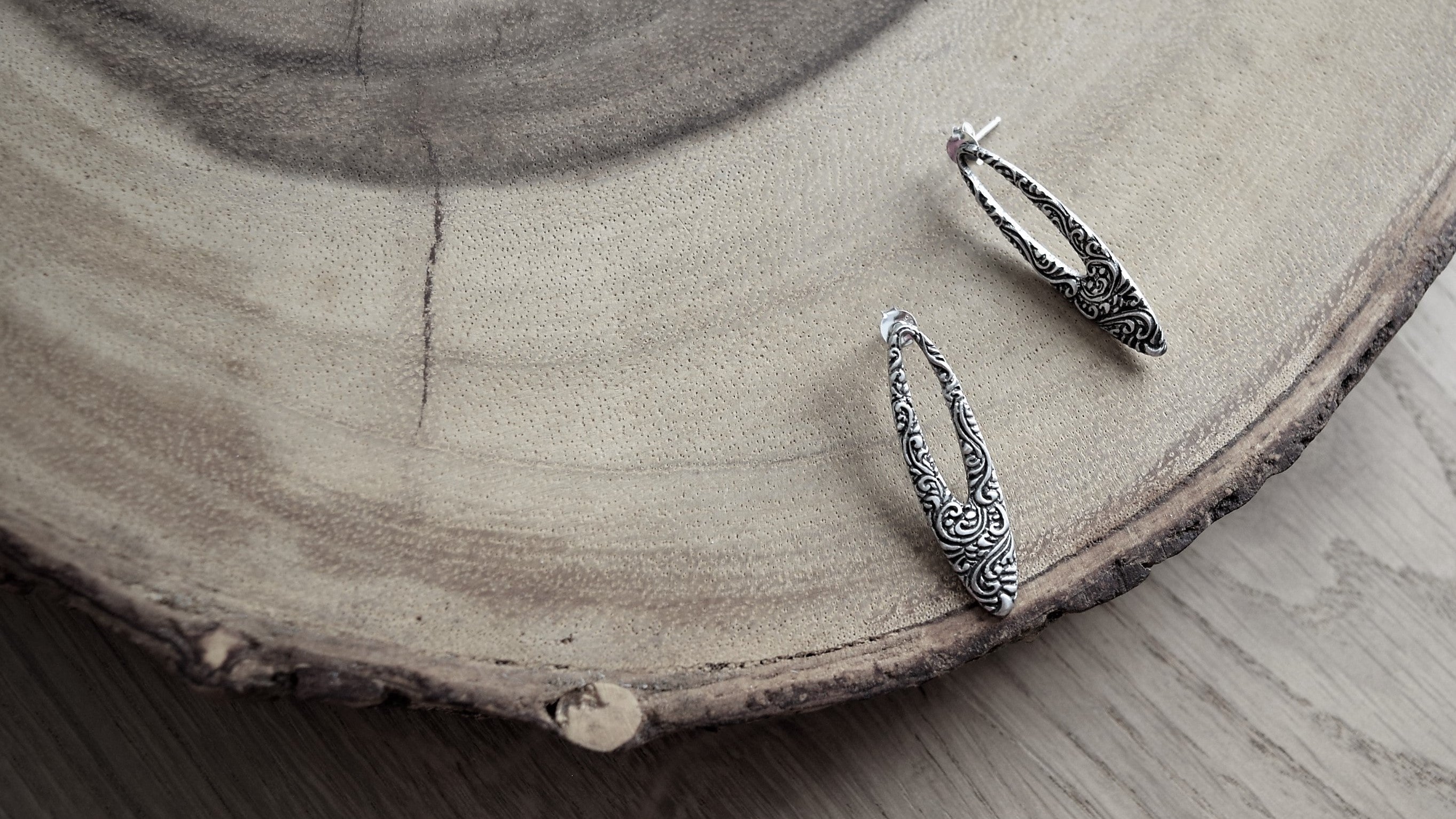 Gift ideas for Chinese New Year and Valentine's Day: simple elegant oval shaped silver earrings with intricate patterns designed in Singapore, handmade in Bali.